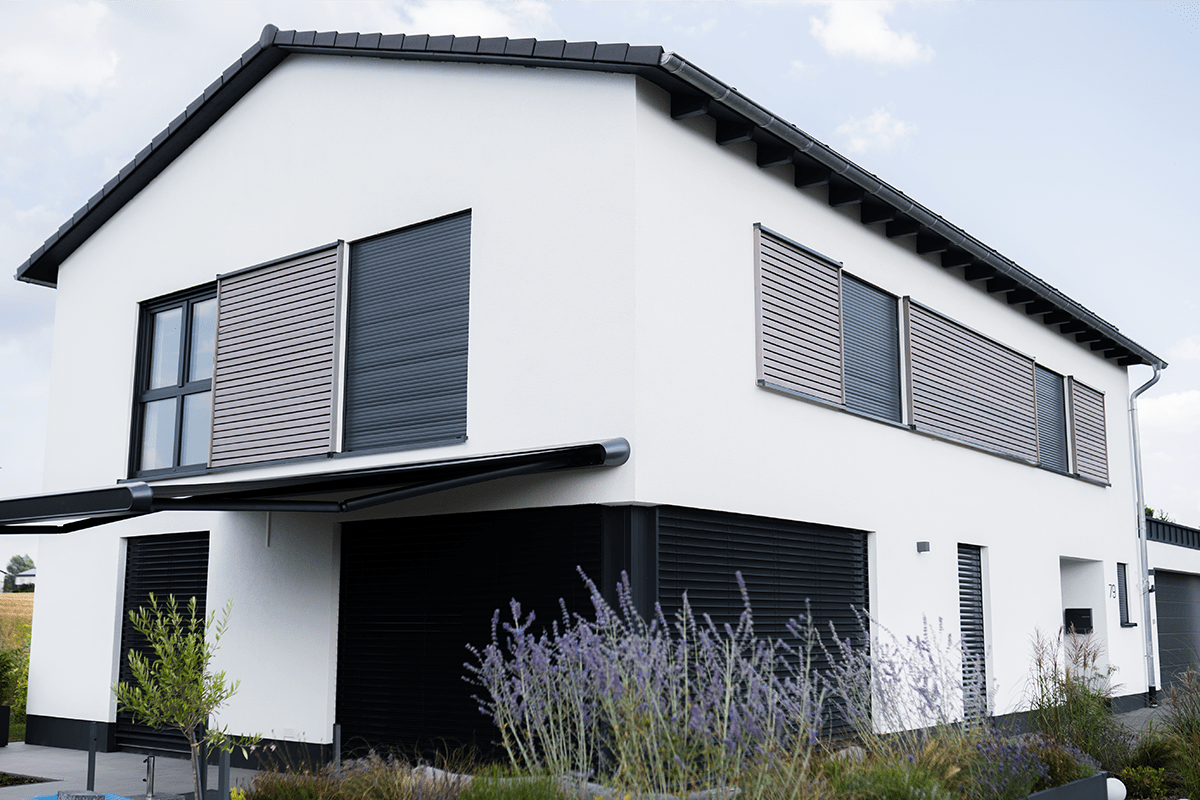 Modernes weißes Haus mit integrierten Rollläden, Steinbrink GmbH Projekt Hausfassade