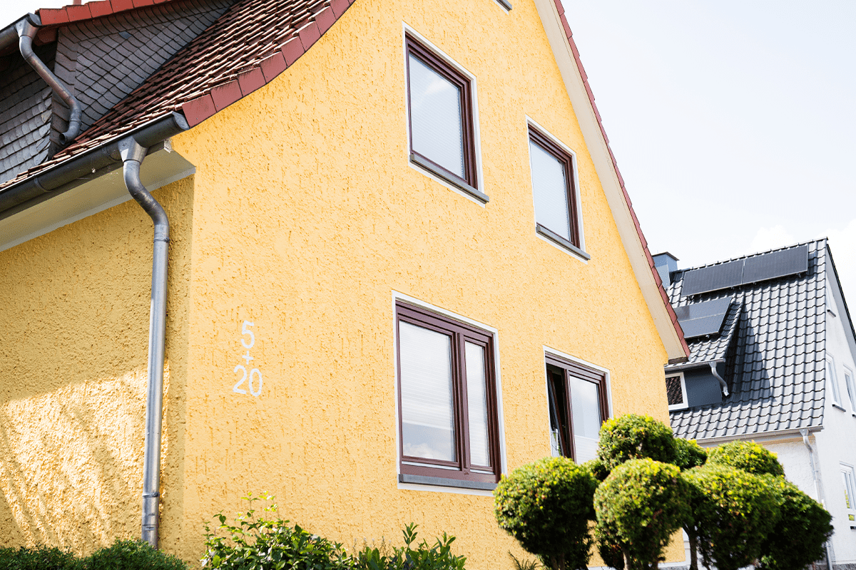 Gelbe Hausfassade mit modernen Fenstern, Projekt der Steinbrink GmbH